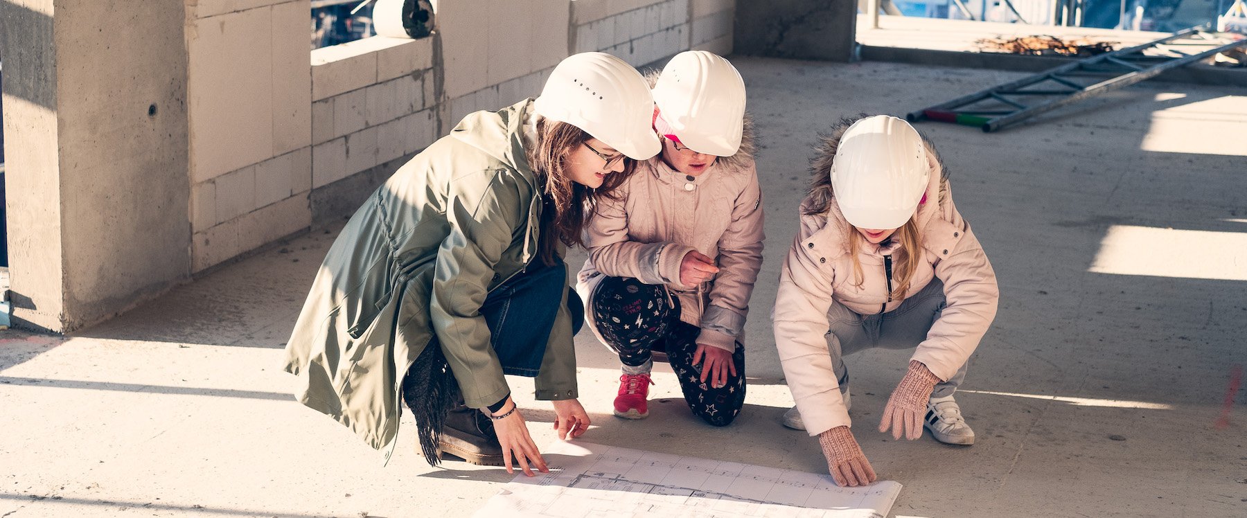 Drei junge Frauen einer inklusiven WG auf der Baustelle ihres neuen Wohnhauses