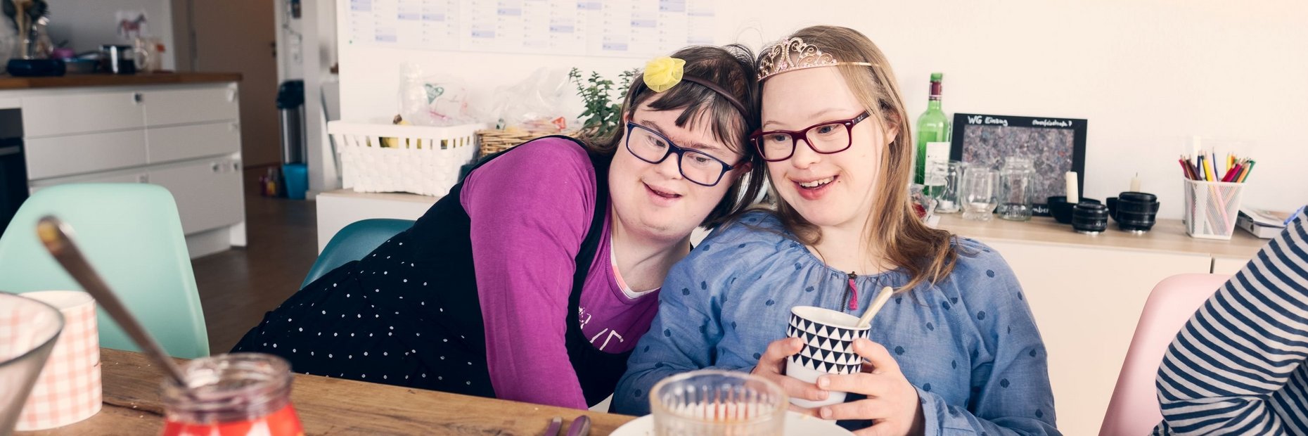 Zwei Mitbewohnerinnen mit Behinderungen sitzen am Frühstückstisch